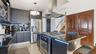 Kitchen featuring island range hood, stainless steel appliances, dark stone counters, hanging light fixtures, and light tile patterned floors